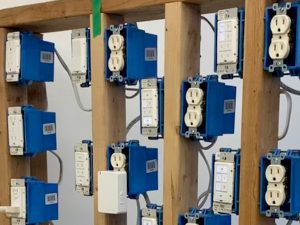 A portion of Insteon's on-site test framework, showing multiple outlets, switches, keypads, and other devices, wired up on a frame made of 2x4s